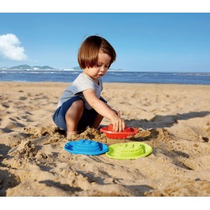 Kind spielt mit Hape Sandspielzeug Strand- und Badebooten (3-teilig, mehrfarbig) am Strand.