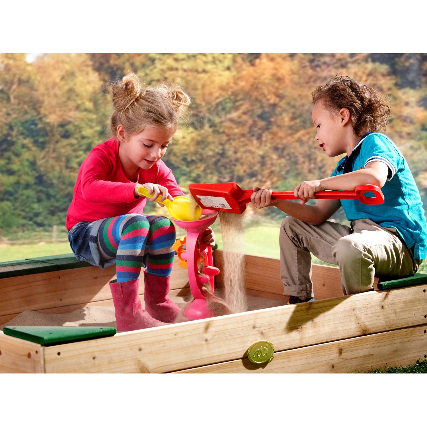 Axi Sandkasten Amy mit zwei Kindern beim Spielen mit Sandspielzeug.