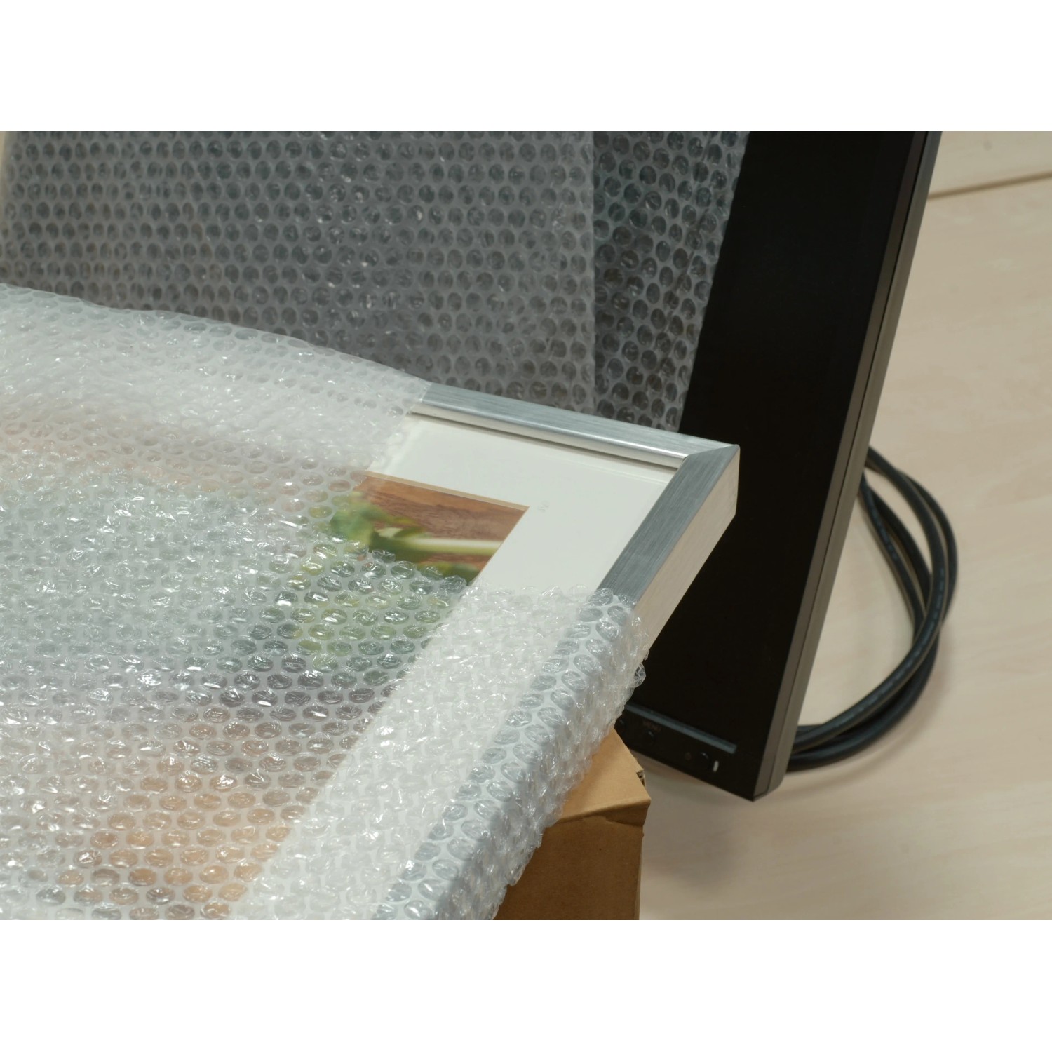 Verpackter Bilderrahmen mit Luftpolsterfolie 0,5 m x 5 m zum Schutz vor Beschädigungen.