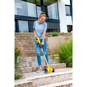 Frau benutzt Gloria WeedBrush li-on Unkrautfugenbürste auf Steintreppe im Garten.