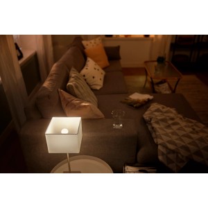 Philips Hue LED-Lampe E14 in Wohnzimmeratmosphäre, warmweißes Licht.