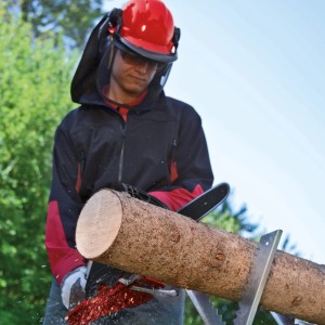 Einhell GE-EC 2240 Elektro-Kettensäge beim Sägen von Holz mit Schutzkleidung.