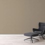 Beige-braune Vliestapete mit leichter Struktur, passend zu modernem Sessel.