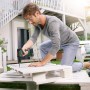 Mann schraubt mit Bosch 18V Akku-Bohrschrauber UniversalDrill 18V Solo ein Brett fest.