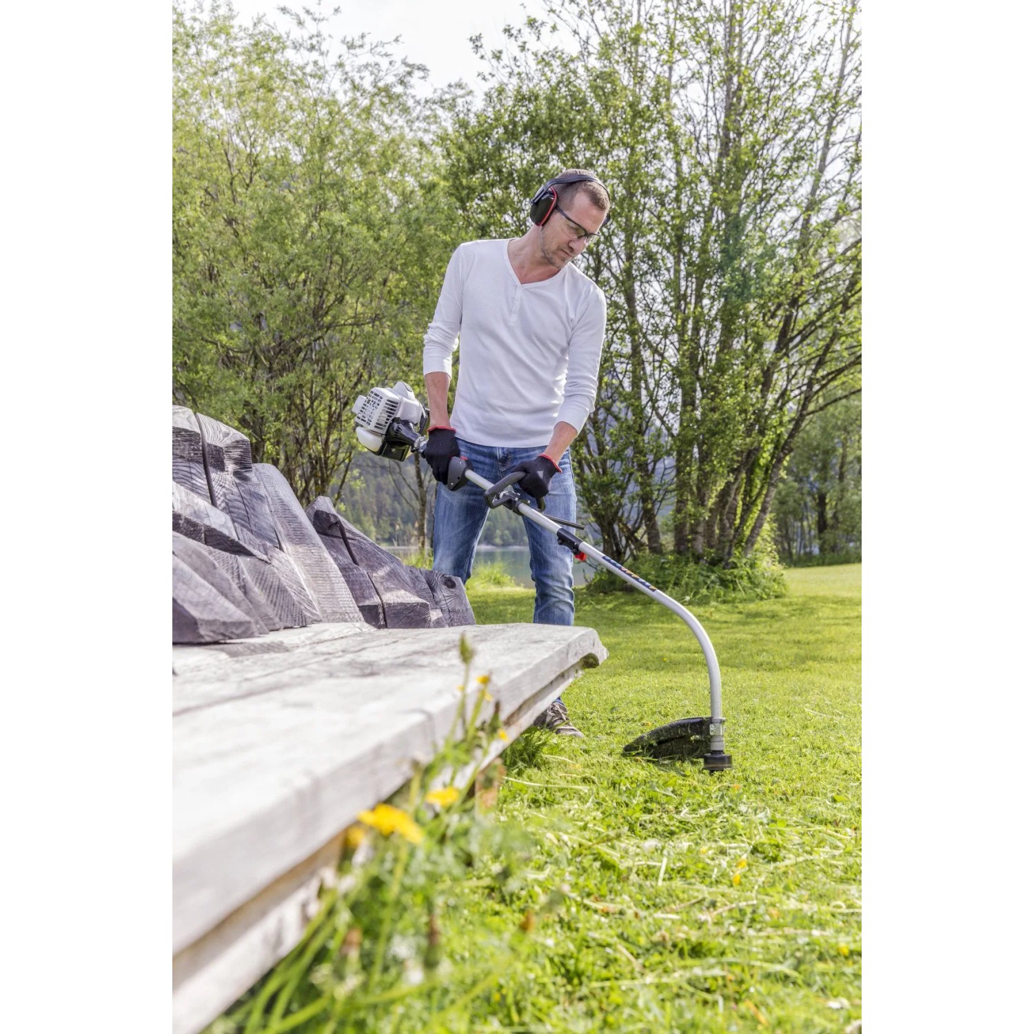 Mann benutzt Al-Ko BC 223 L-S Benzinmotorsense im Garten für präzises Trimmen.