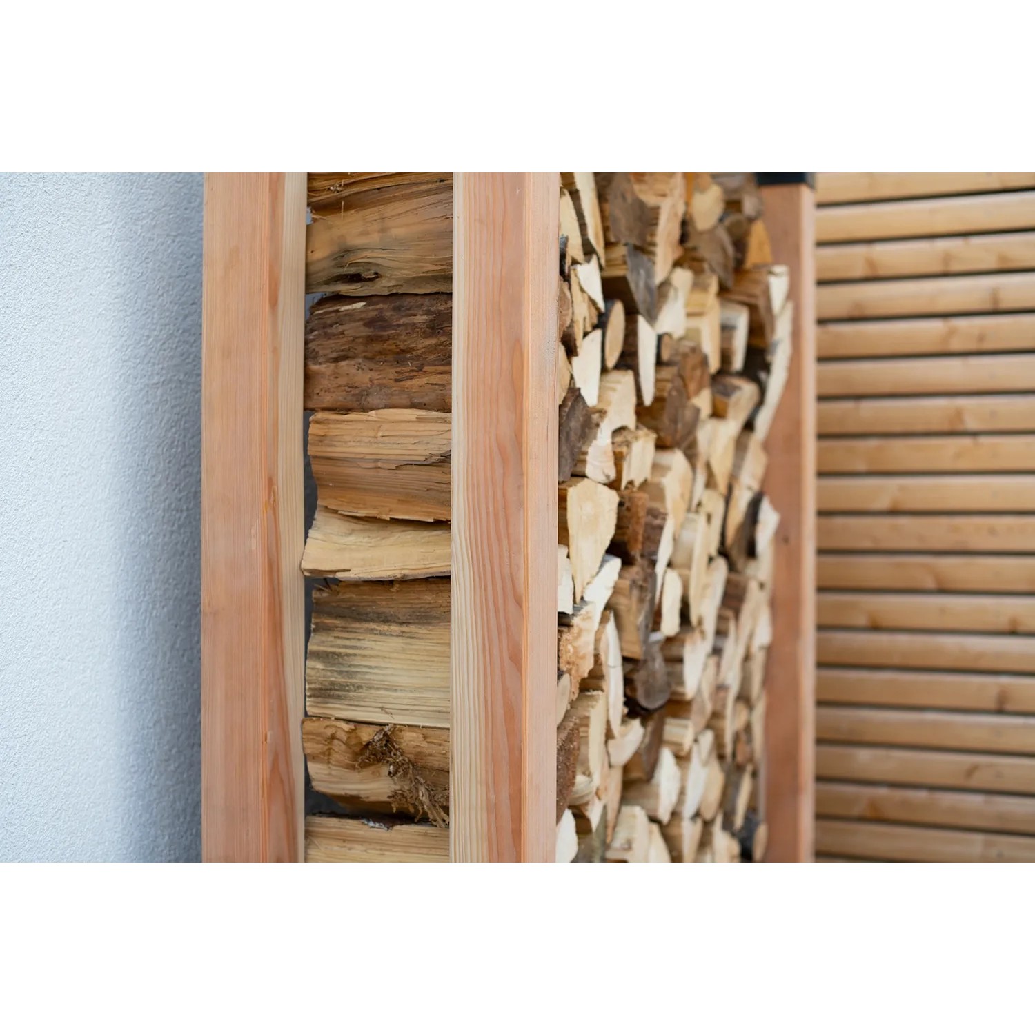 Westmann Kaminholzregal Michel XL aus Lärchenholz, gefüllt mit Kaminholz.