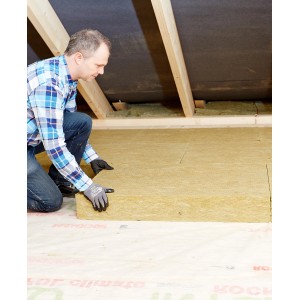 Mann verlegt Rockwool Tegarock Dachbodendämmung (180mm) auf einem Dachboden.