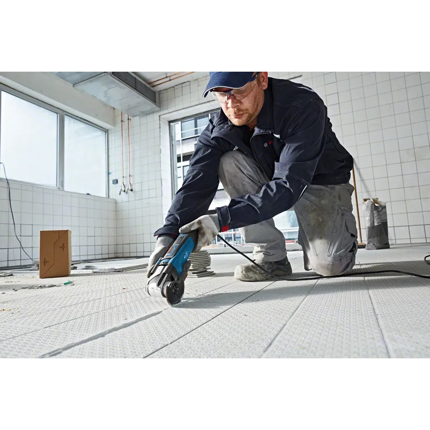 Bosch Professional GOP 55-36 Multicutter im Einsatz beim Schneiden von Bodenbelag.