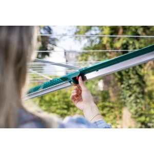 Hand bedient Leifheit Linomatic 400 Deluxe Wäschespinne. Grüner Arm mit rotem Knopf für Easy Lift System im Garten.