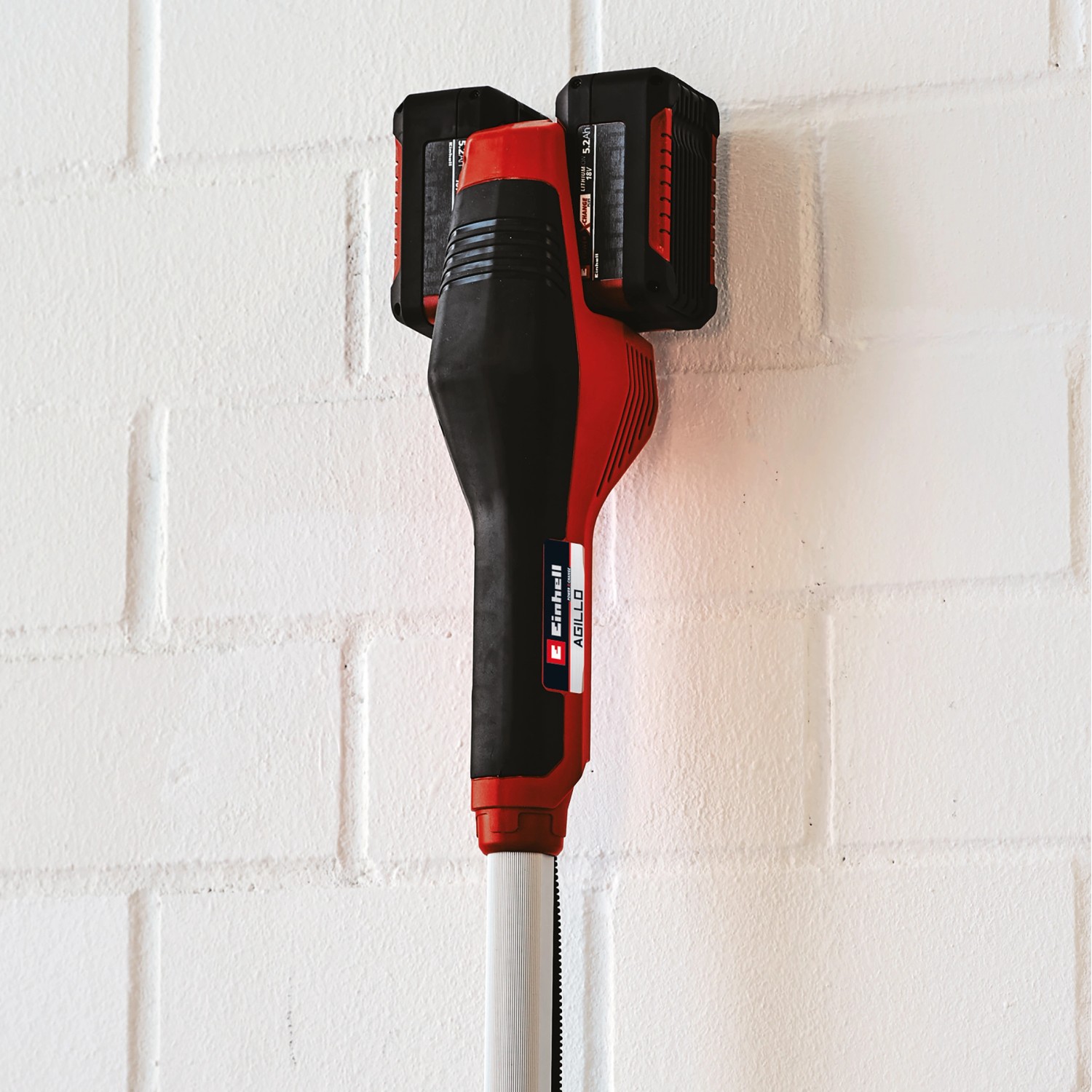 Einhell Akku-Sense Agillo Power X-Change Solo mit zwei Akkus an einer Wandhalterung.