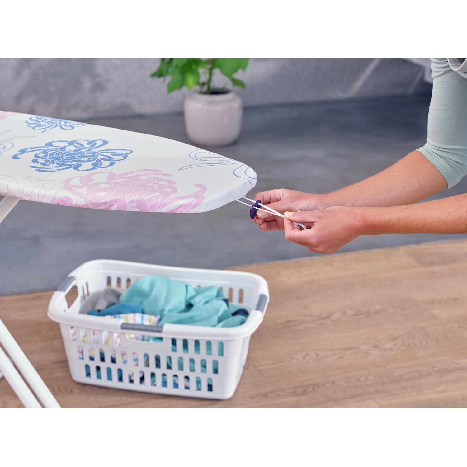 Leifheit Bügeltischbezug Cotton Classic M mit Blumenmuster wird auf Bügeltisch befestigt.