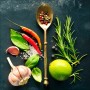 Leinwandbild Vintage Herbage III: Nahaufnahme von Gewürzen, Kräutern und Knoblauch auf dunklem Grund.