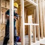 Handwerker bohrt mit Bosch Expert Flachfräsbohrer Loch in Holzkonstruktion.