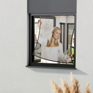 Frau montiert anthrazitfarbenes Windhager Fenster IS Pop-Up Screen Insektenschutzgitter (100x120cm).