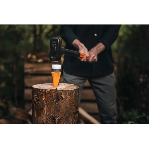 Fiskars Dreh-Spaltkeil Safe-T in Aktion mit Hammer auf Holzstamm, sicheres Spalten von Holz.