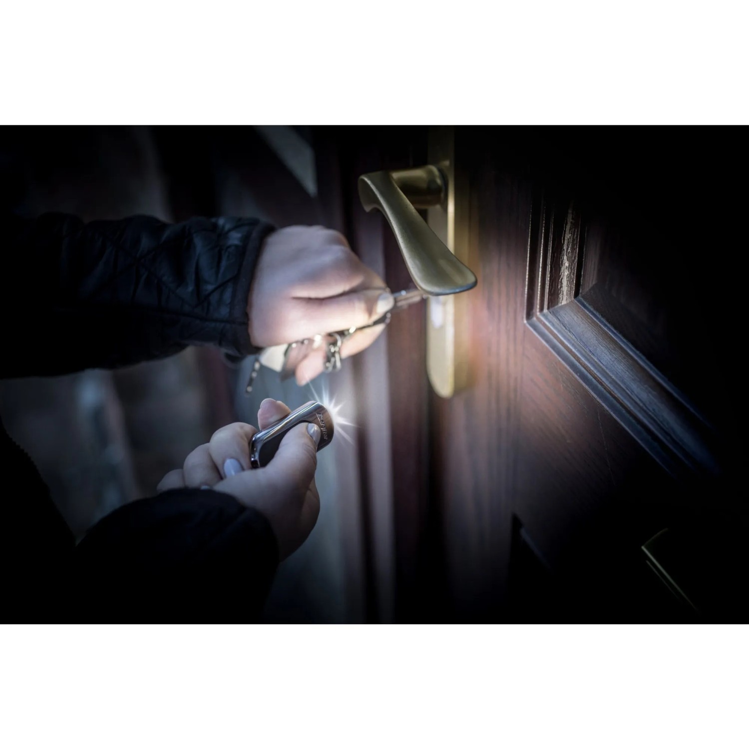 Energizer Schlüsselanhänger-Taschenlampe leuchtet beim Aufschließen einer Tür.