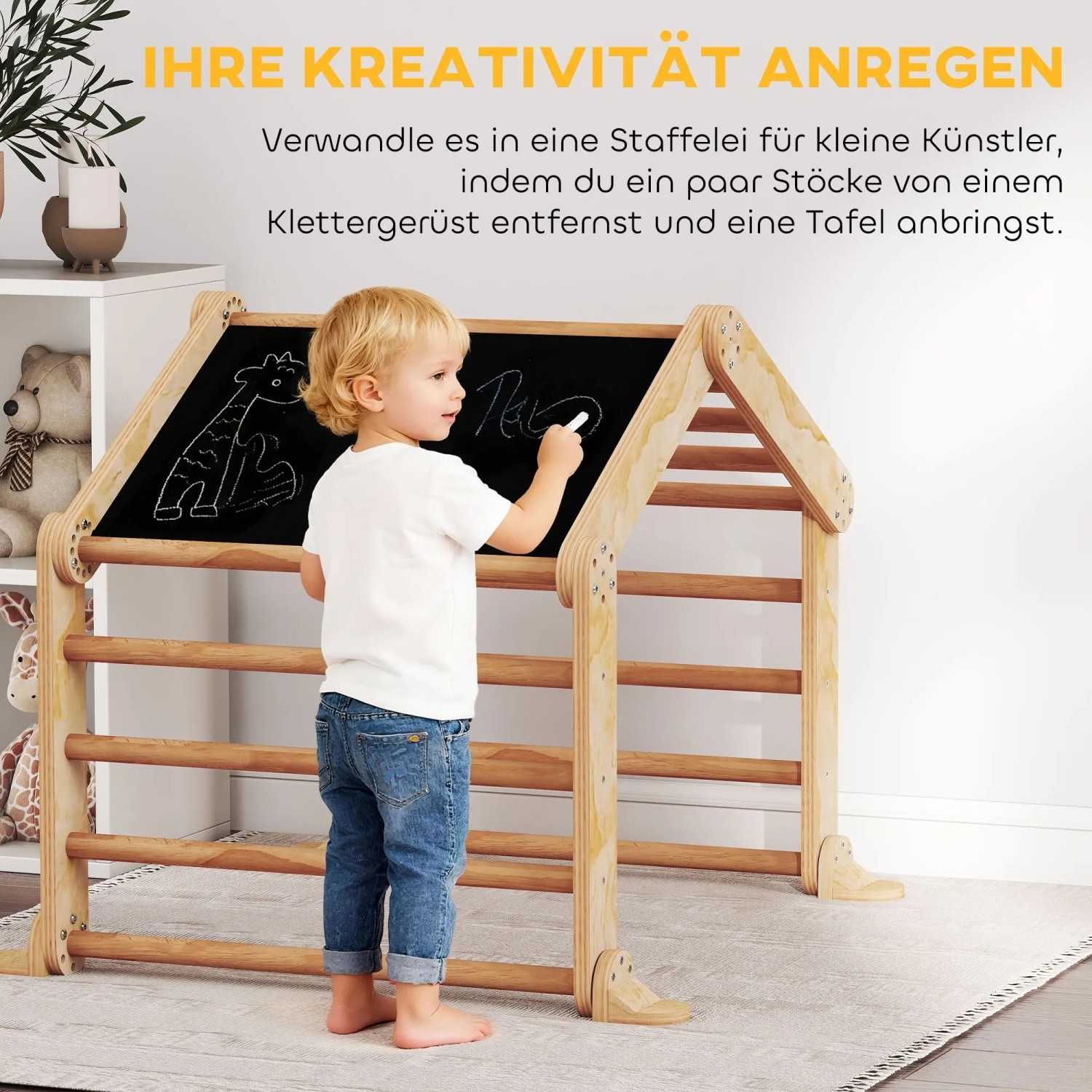 Kleinkind malt mit Kreide auf schwarzer Tafel des hölzernen AIYAPLAY Klettergerüsts. Fördert Kreativität & Motorik.