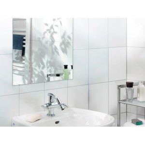 LUX Montageband im Badezimmer: Spiegel, Waschbecken und Armatur an weiß gefliester Wand.