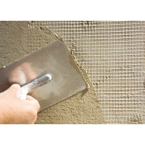 Verputzen einer Wand mit Catnic Innenputzgewebe (75 g/m²) und einer Glättkelle.