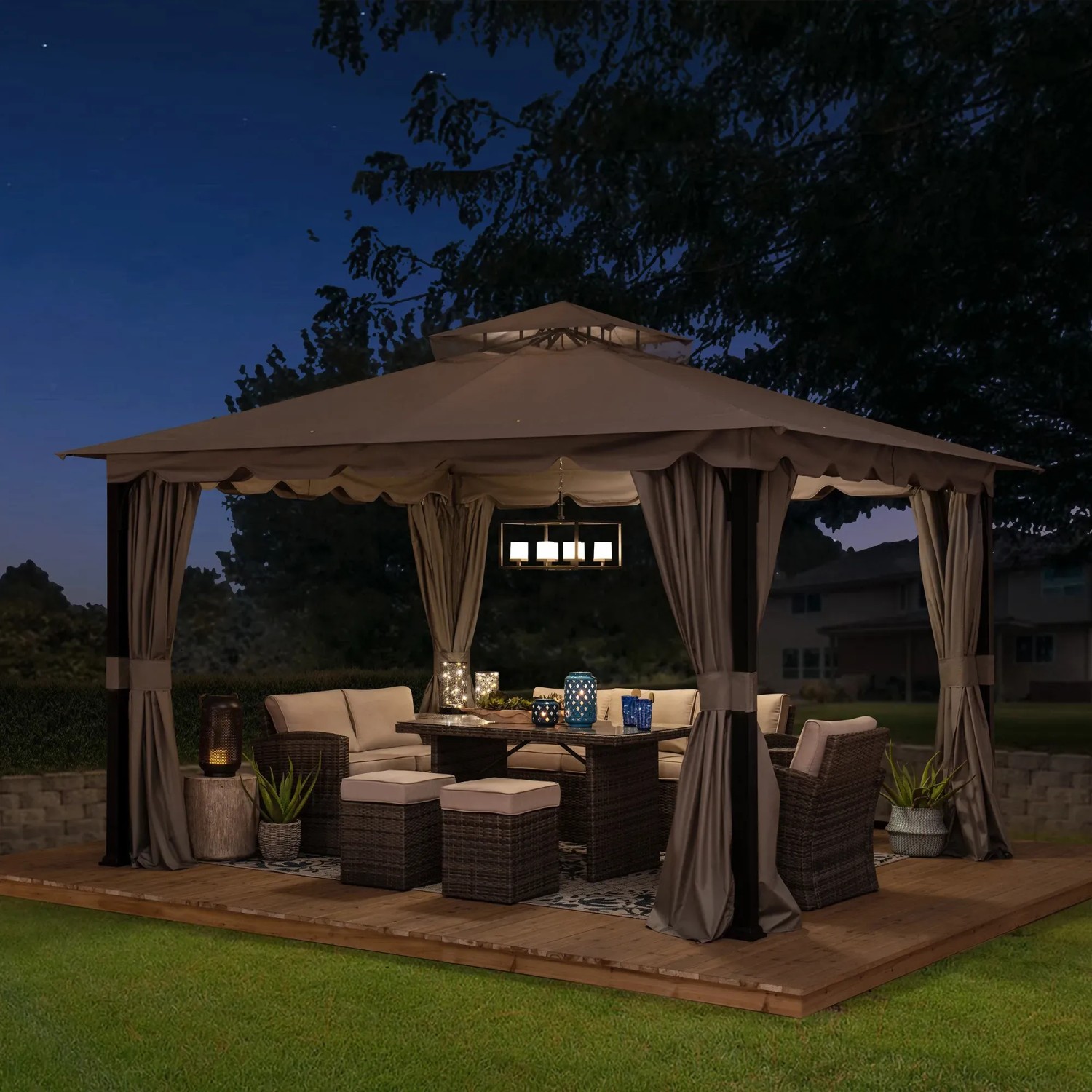 Grauer Sunjoy Gazebo Stoj Pavillon (336x402 cm) mit Vorhängen und Möbeln auf einer Holzterrasse.