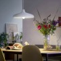 Philips LED-Lampe E27, ultraeffizient, 7,3W, in Glühlampenform unter weißer Hängelampe über Esstisch.