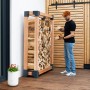 Westmann Kaminholzregal Michel XL aus Lärchenholz (FSC®) mit Holzscheiten und einer Person.