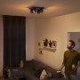 Schwarzer Philips Hue LED-Spot mit 4 Leuchten im Wohnraum, warmweißes Licht.