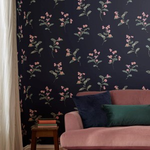 Joules Vliestapete Swanton Floral in Marineblau mit Blumenmuster, kombiniert mit Sofa und Deko.