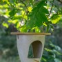 Dobar Vogelfutterspender Eco aus Pflanzenfasern mit Bambusdeckel, hängend an einem Baum.