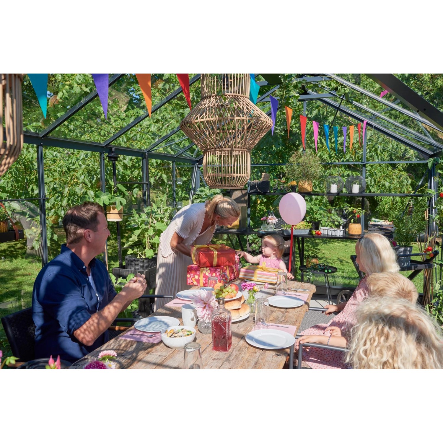 Familie feiert im Juliana Gewächshaus Orangerie 21 Schwarz-Anthrazit mit Partydeko.