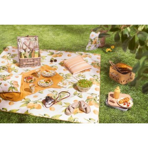 Camping-Szene mit Tablett mit Zitronenmuster, Picknickdecke, Geschirr und Speisen im Freien.
