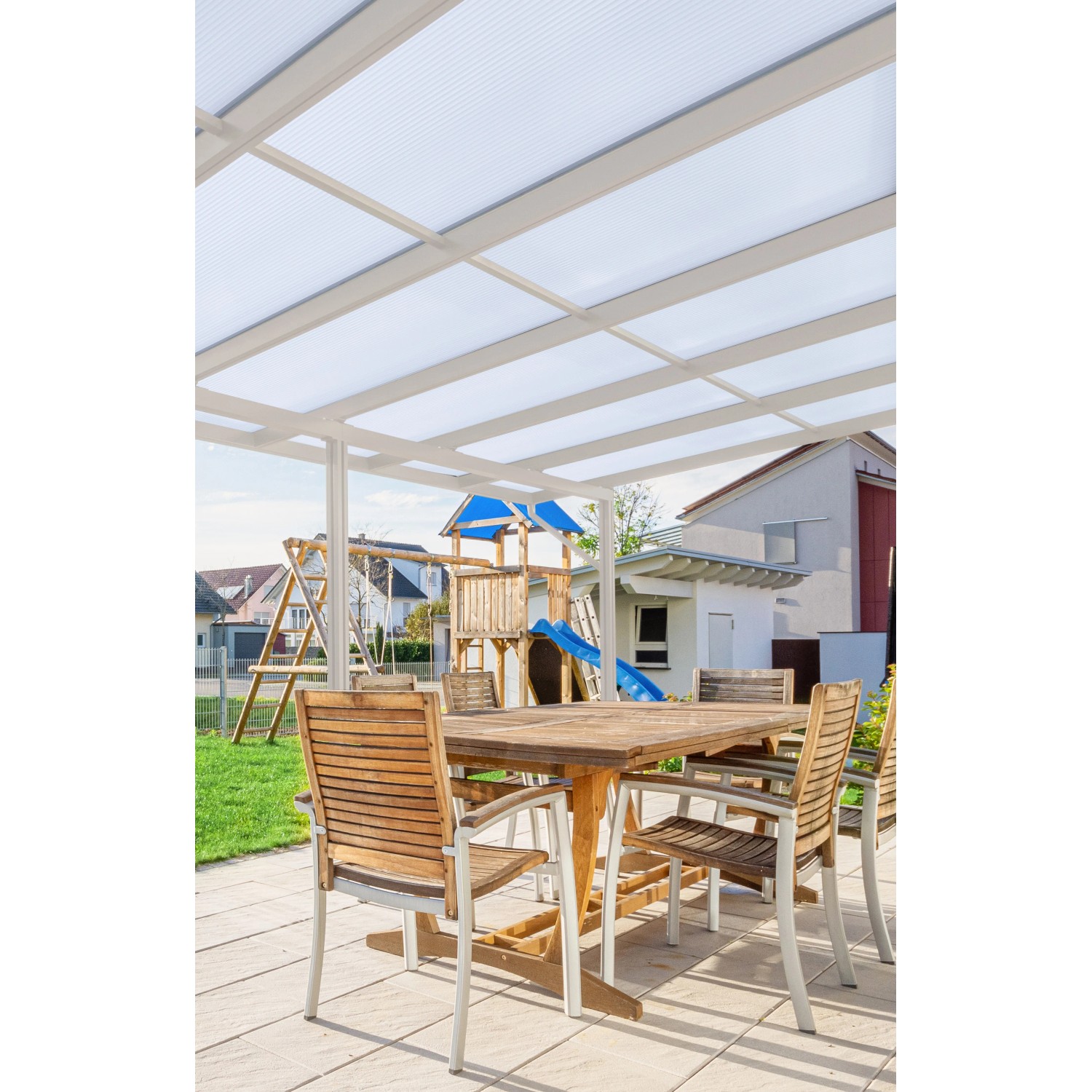 Weiße Gutta Terrassenüberdachung Premium mit Stegplatten und Sitzgruppe im Garten.
