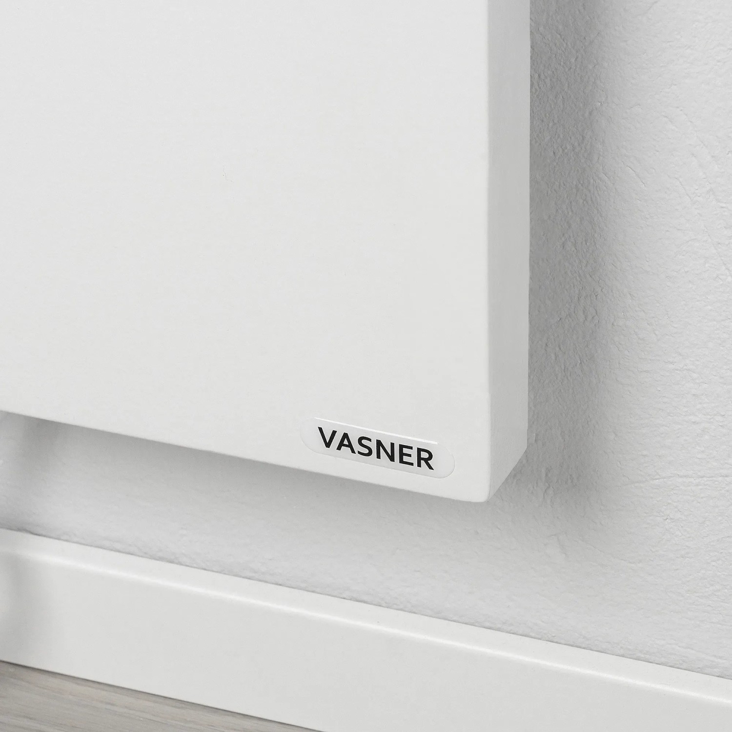 Weiße Vasner Konvi RX Infrarotheizung (600 W) an Wand montiert. Elektrische Heizung mit Funk-System.