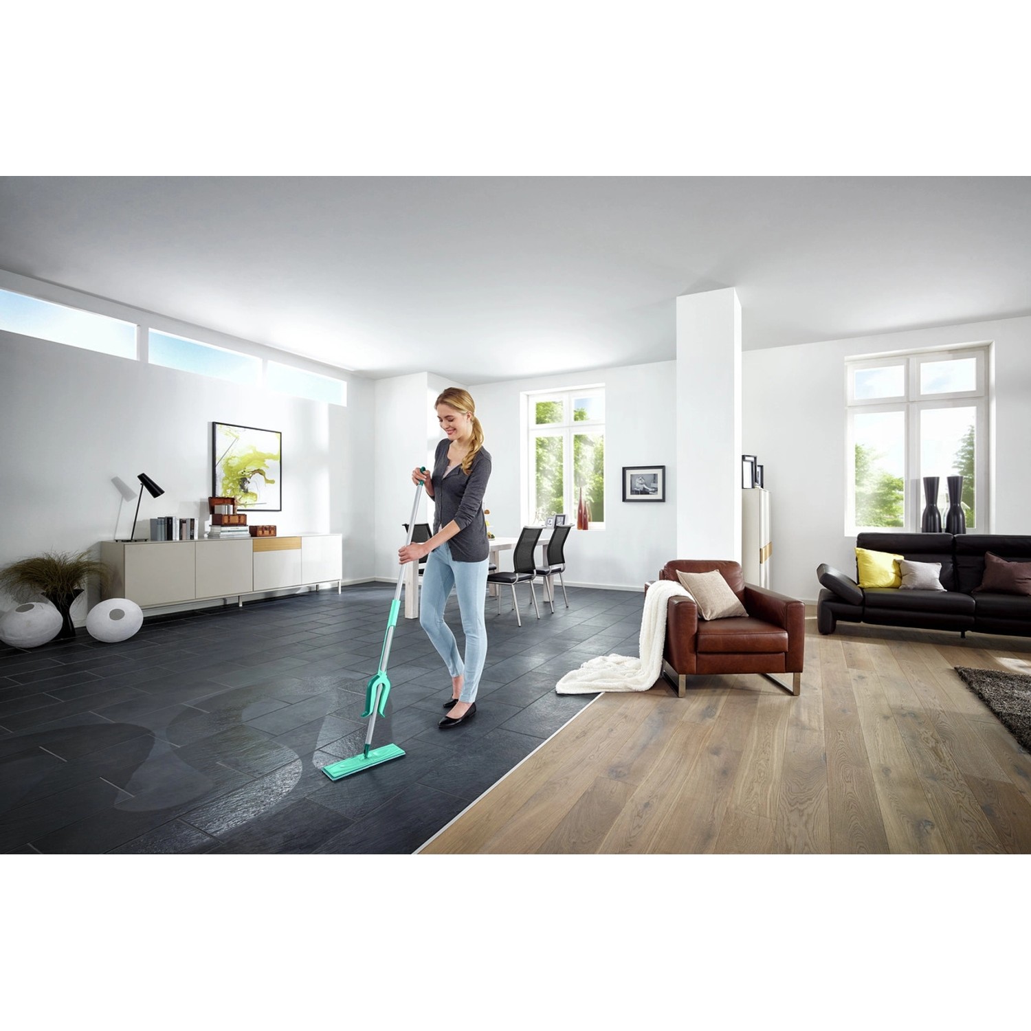 Frau wischt Boden mit Leifheit Picobello XL Bodenwischer in modernem Wohnzimmer.