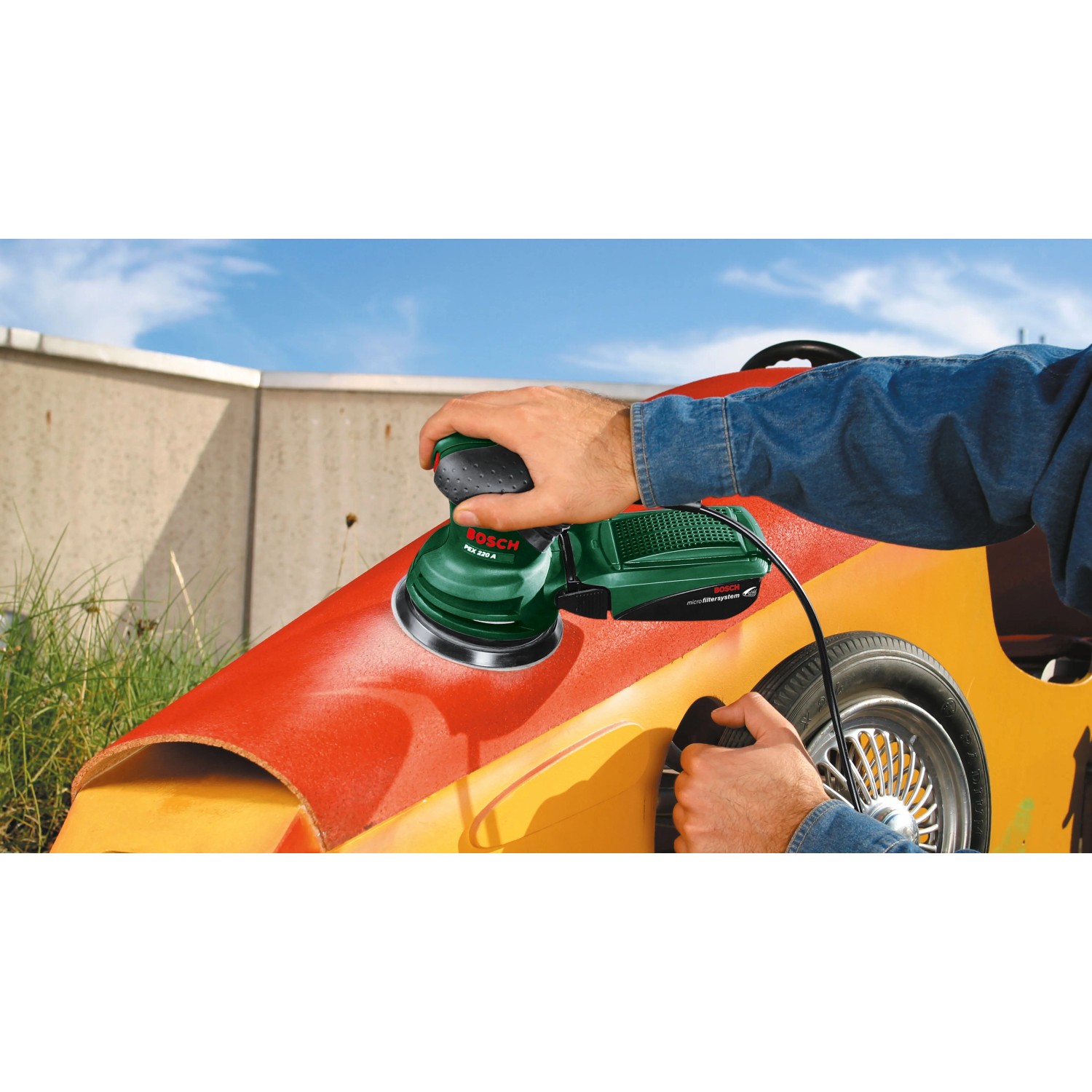 Bosch Exzenterschleifer PEX 220 A, grün, schleift rote Oberfläche eines Objekts. Ideal für feinen Schliff.