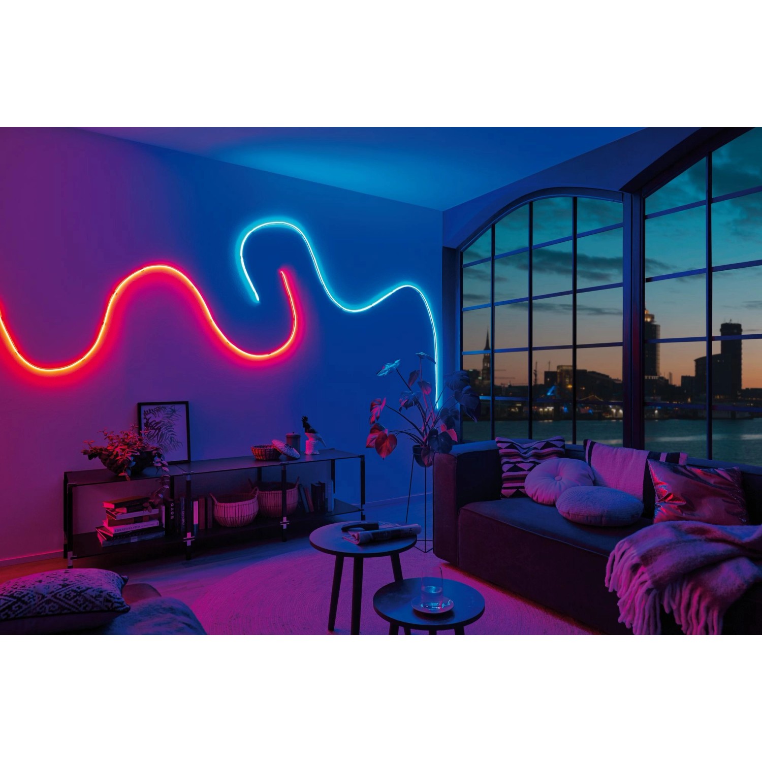 Paulmann MaxLED Flow RGB LED-Streifen Set an Wand im Wohnzimmer, rot und blau leuchtend.