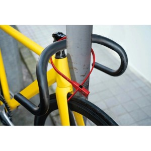 Rotes Basi Kabelschloss KBS 50 sichert gelbes Fahrrad an einem Pfosten.