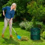 Frau rechen mit Gardena Combisystem Schaufel-Rechen Gras zusammen. Vielzweckgerät für Gartenarbeit.