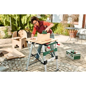 Frau schleift Holz auf der Bosch PWB 600 Werkbank im Garten.